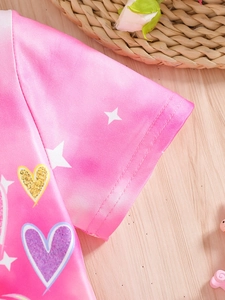Détail de la manche d'un t-shirt rose pour fille avec motifs cœurs à paillettes