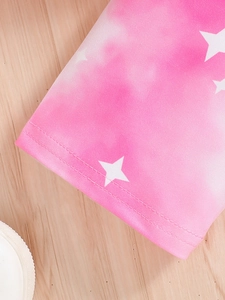 Détail du tissu rose tie-dye avec imprimé étoiles et coutures doubles sur l'ourlet