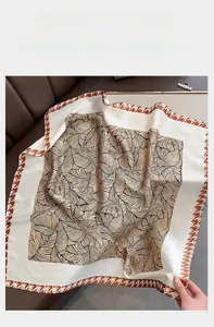 Dettaglio dell'elegante foulard di seta con trama a venature e bordo in pied de poule