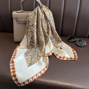 Elegante foulard in seta con motivi a venature di foglie su una borsa di lusso