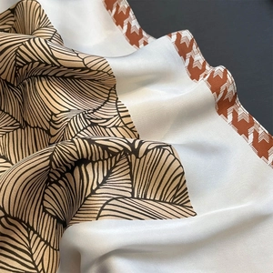 Elegante foulard in seta con venature di foglie e bordo chevron in toni caffè