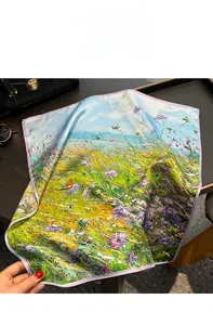 Detail of oil painting style mulberry silk scarf with floral print on a wooden desk