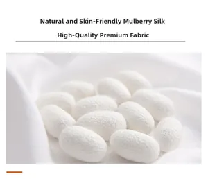 Macro shot of natural mulberry silk cocoons on soft white pure silk fabric background