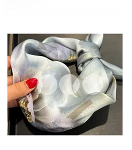 Gros plan d'un foulard en soie aux motifs floraux montrant sa texture douce et lisse