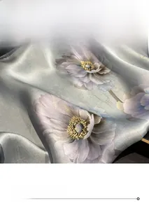 Vue macro de l'écharpe en soie montrant des coutures fines et des motifs floraux