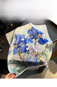 Detailed shot of retro blue iris print silk scarf featuring fine purple edge stitching