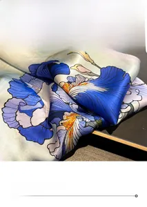 Close-up of premium silk scarf featuring blue iris floral patterns and fine stitching