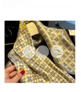 Texture détaillée du foulard en soie aux motifs floraux jaunes et blancs et fini lisse