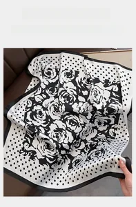 Detailaufnahme der seidigen Textur und des floralen Punktmusters des quadratischen Tuchs