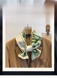Dettaglio di sciarpa in seta verde con motivo acquerello su un blazer marrone elegante
