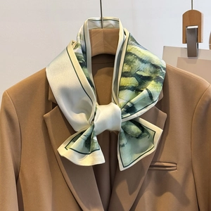 Elegante sciarpa in seta con stampa acquerello verde e gialla su un blazer cammello