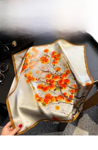 Detailed close-up of retro silk scarf with floral patterns on a stylish handbag