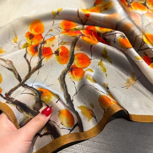 Macro view of silk scarf texture with traditional persimmon print and refined edges