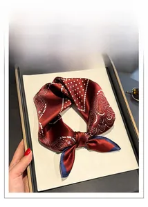 Close-up of luxury paisley silk square scarf in burgundy with elegant dot patterns