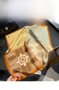 Detailansicht eines Seidenschals mit Paisley-Muster und schickem orangefarbenem Rand