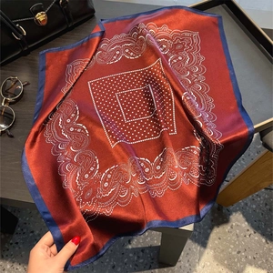 Elegant silk square scarf with paisley pattern and dots, styled with premium handbag