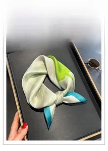 Macro detail of high-quality silk square scarf with geometric pattern in green and blue
