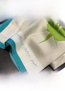 Detailed close-up of fine hemmed edges and silk texture on green leaf pattern scarf