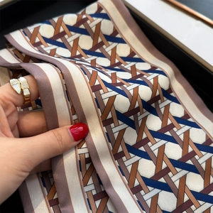 Macro shot of geometric weave print silk scarf tied as a luxury wrist accessory