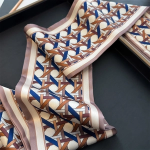 Macro view of woven geometric pattern on a long satin scarf with fine lavender edges