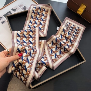 Detail of classic woven long silk scarf with geometric pattern in elegant lifestyle setting