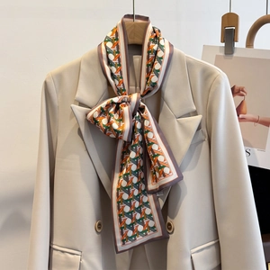 Detail of silk-like neck scarf with geometric weave pattern on a beige blazer