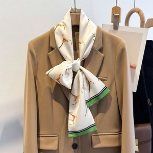 Eleganter Seidenschal mit Calla-Lilien-Print als Schleife an einem Kamel-Sakko-Kragen