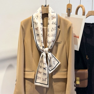 Elegant white silk scarf with colorful horse print styled on a khaki suit blazer