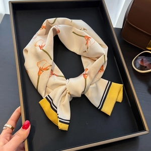 Eleganter Seidenschal mit Calla-Lilien-Print als Schleife gebunden auf einem Tablett