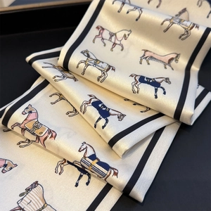 Detailed view of horse print skinny silk scarf with elegant black border and satin texture