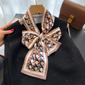 Classic woven pattern silk scarf tied as a bow on a wooden hanger with tweed vest