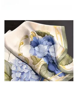 Detail of silk square scarf featuring blue hydrangea print and golden vine patterns