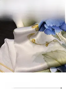 Detail of fine rolled hem edge on silk floral scarf with blue hydrangea print patterns