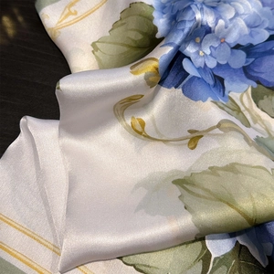 Elegant mulberry silk scarf with blue hydrangea floral pattern on pearl white satin