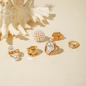Detail of 5-piece baroque pearl ring set with gold geometric textures and shell decor