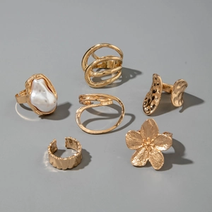 Detailed view of 6-piece gold-tone ring set with baroque pearls and floral patterns