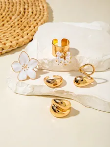 Detailed set of five gold-toned alloy rings with baroque pearls and white enamel flowers