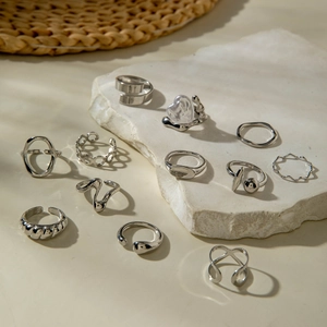 Detail of 11-piece silver ring set with heart and baroque geometric patterns on stone