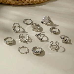 Set of 11 silver-colored geometric rings featuring baroque pearls and floral patterns