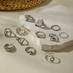 Close-up of 11-piece silver-tone ring set featuring geometric and baroque pearl designs