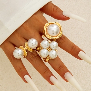 Close-up of geometric Baroque pearl ring set with three gold alloy floral branch bands