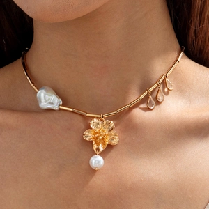 Detail of gold starfish flower necklace with baroque pearls on neck for summer styling