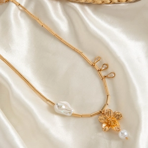 Macro detail of vintage gold starfish flower necklace with baroque pearl on white silk