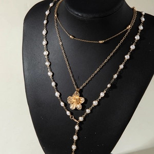 Close-up of layered gold starfish flower necklace with elegant white pearl pendants