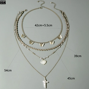 Detailed view of layered gold necklace with butterfly pendants and length measurements