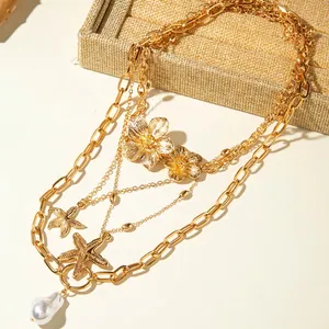 Bohemian gold layered necklace with starfish charms, metal flowers and baroque pearl