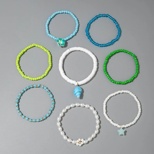 Detail of 8-piece bohemian beaded bracelet set featuring sea shells and flower charms