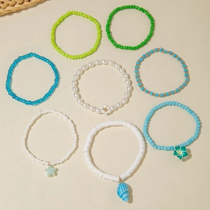 Set of eight bohemian beaded bracelets with faux pearls and colorful charms in summer style
