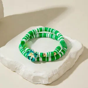 Détail de bracelets bohèmes perlés avec pendentif fleur verte sur pierre blanche