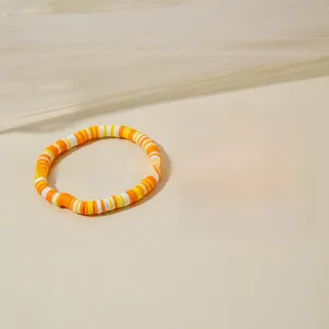 Détail du pendentif fleur bohème avec perles en argile colorées et accents dorés